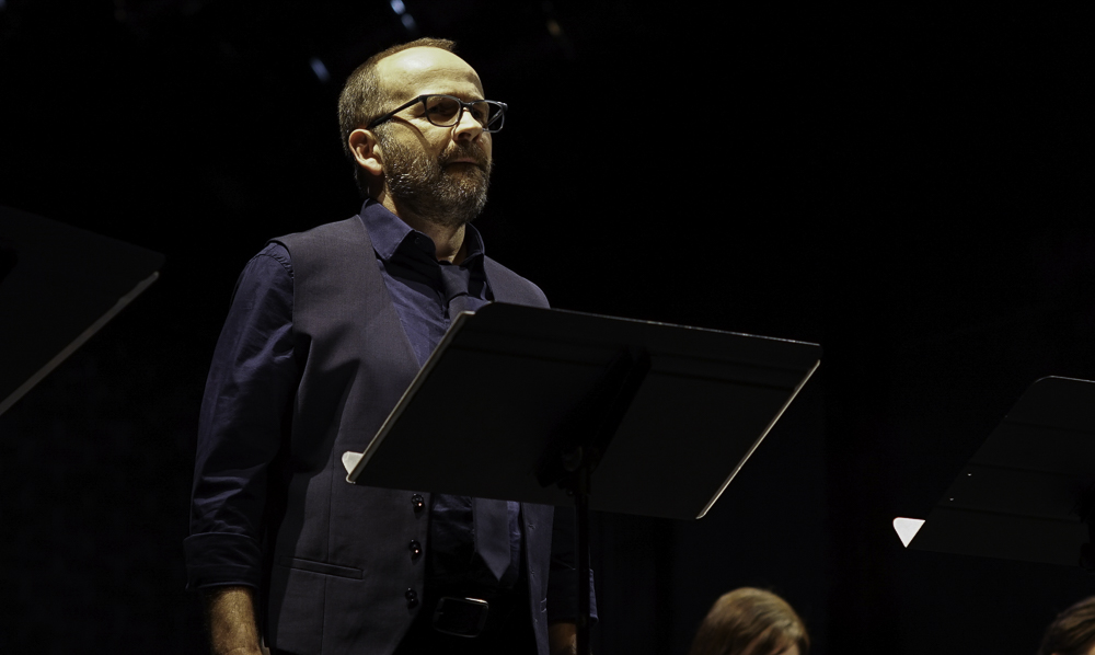 Actor performing at a music stand under theatrical lighting photographed by Rory Duffy