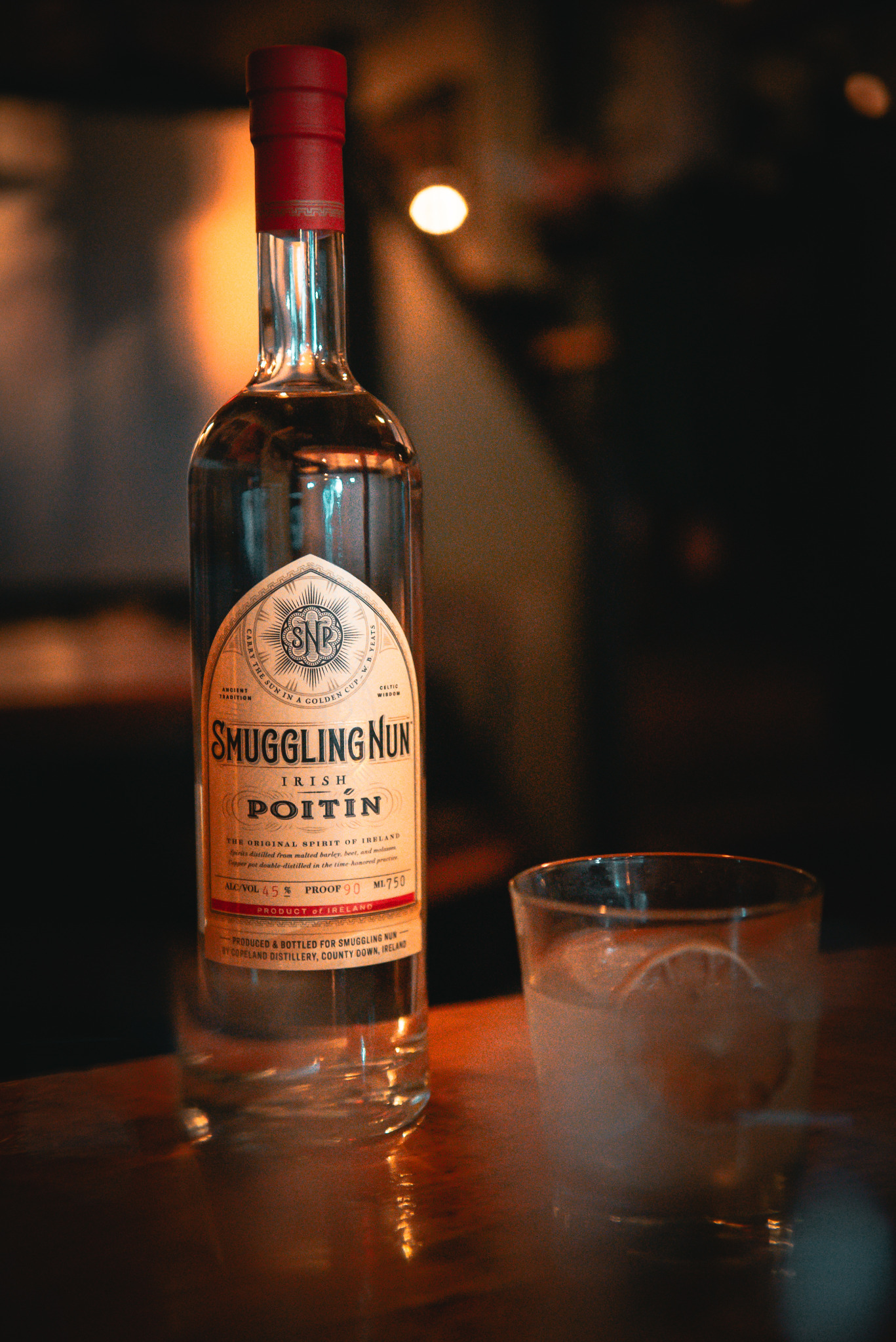 Smuggling Nun Irish poitín bottle photographed in warm bar light by Rory Duffy