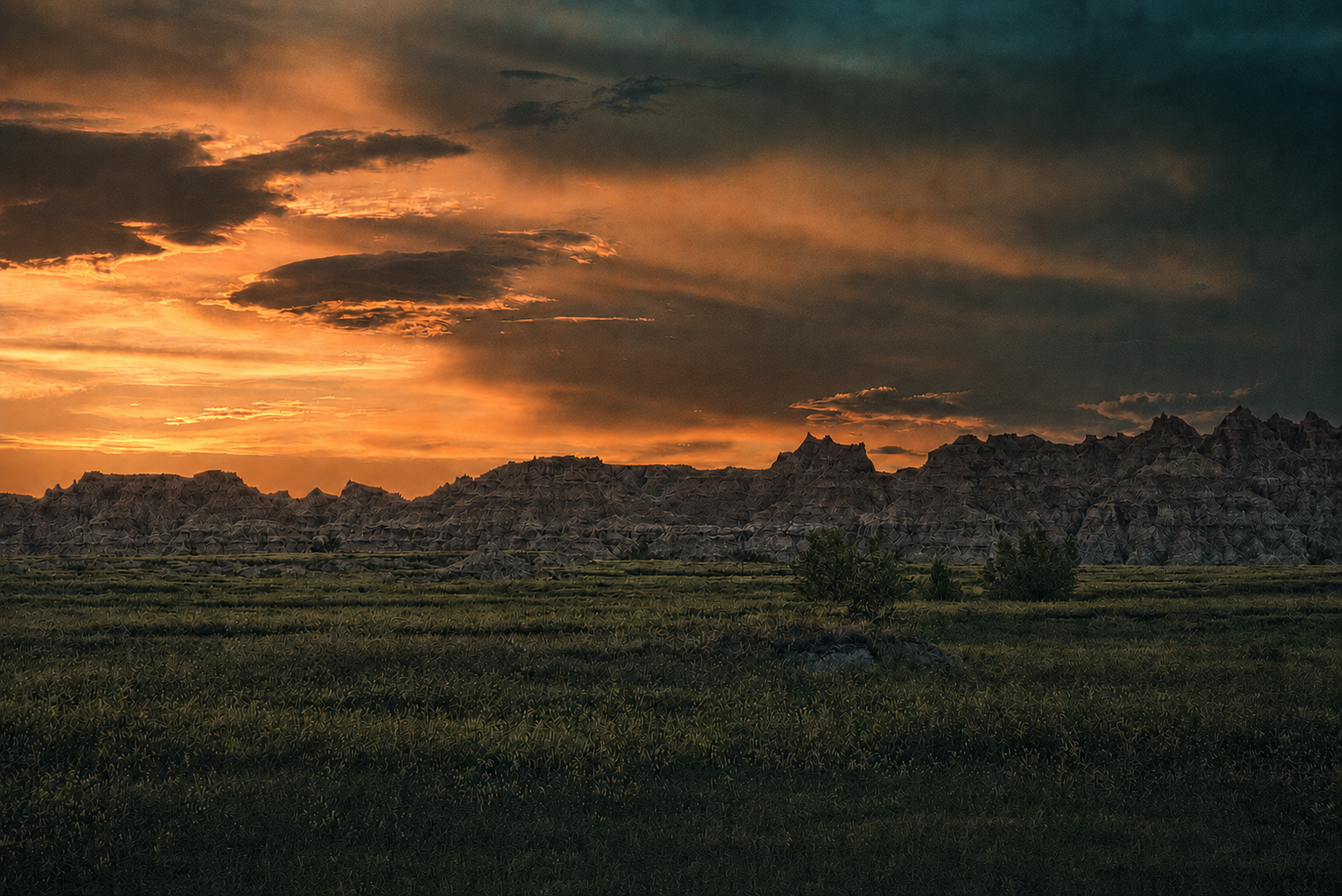 Badlands silhouetted beneath a dramatic orange sunset photographed by Rory Duffy