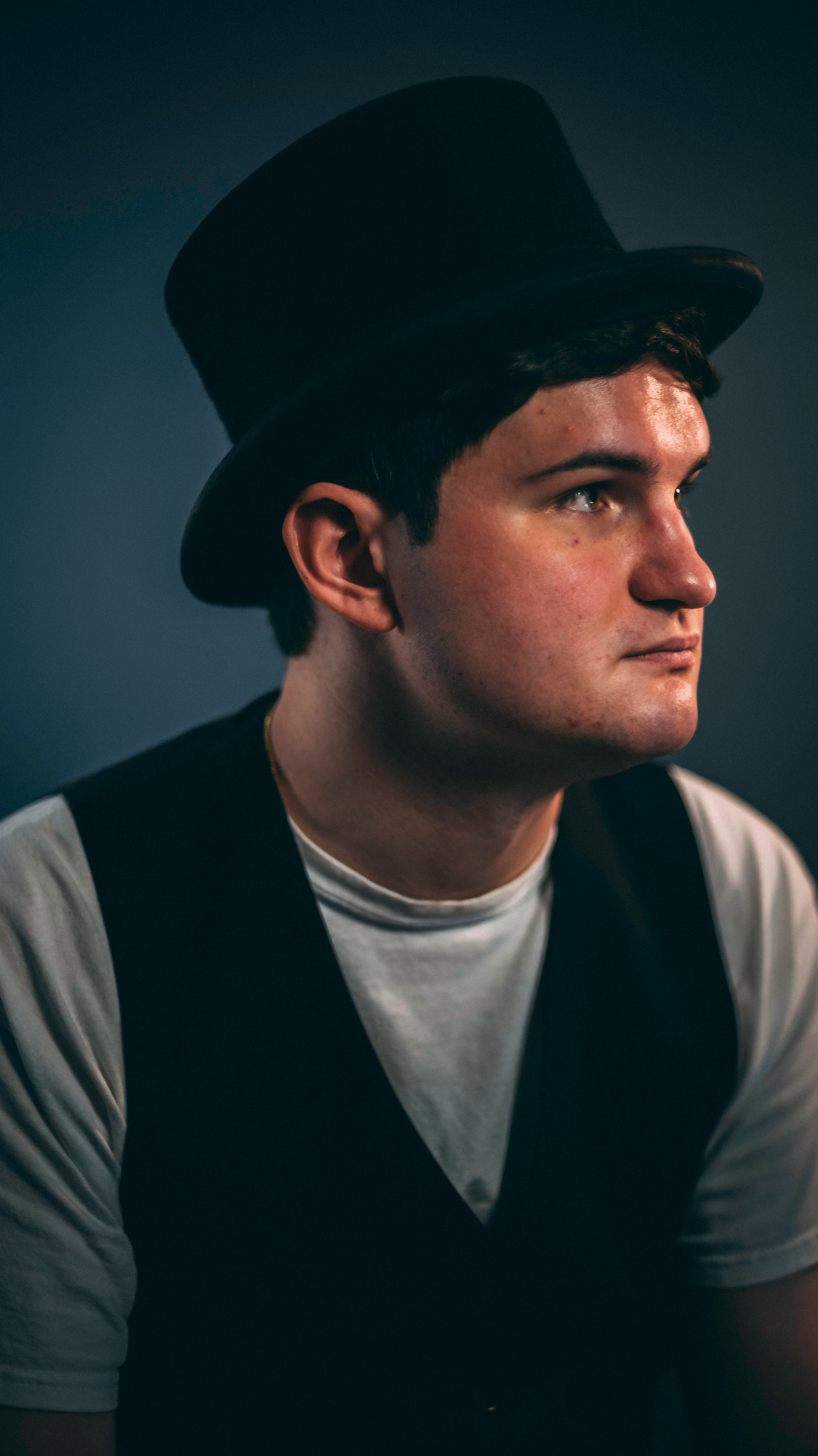 Dramatic theatrical portrait of a performer in a black top hat photographed by Rory Duffy